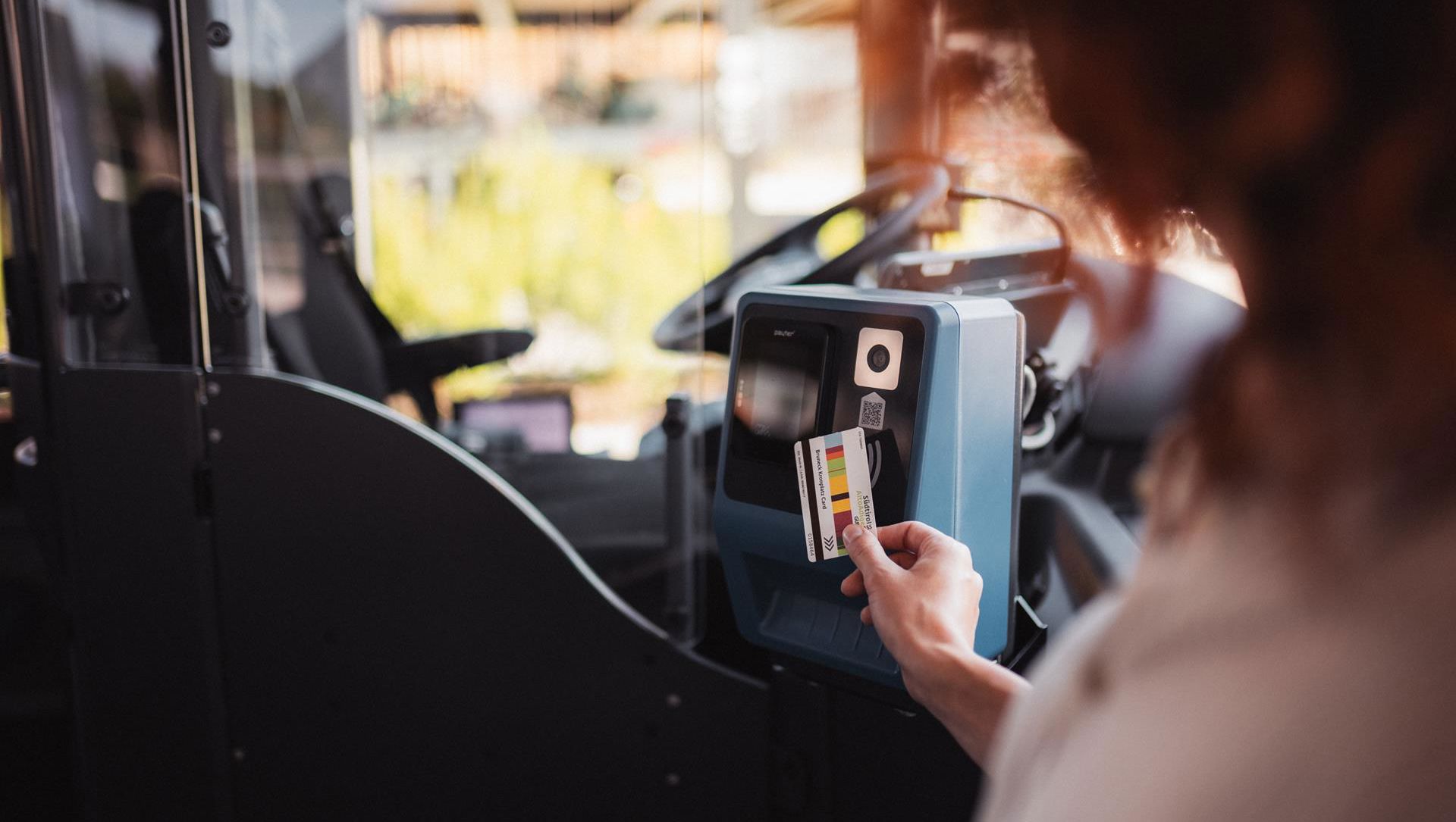 Eine Frau nimmt den Bus mit der Guest Card Schenna