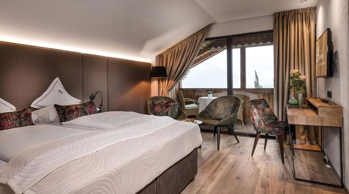 Bedroom of the Starkenberg Suite with a double bed, desk, TV, and balcony