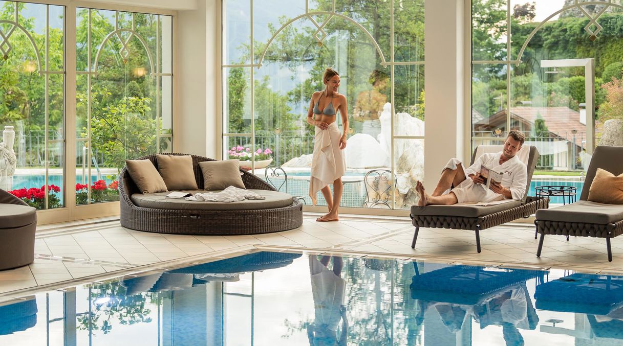 Two guests are relaxing at the indoor pool of our wellness hotel near Merano/Meran