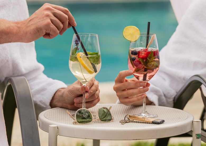 Two people have a drink at the outdoor pool