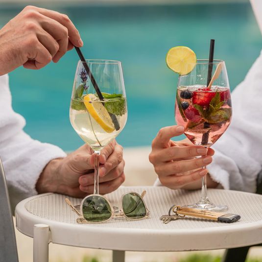Two people have a drink at the outdoor pool