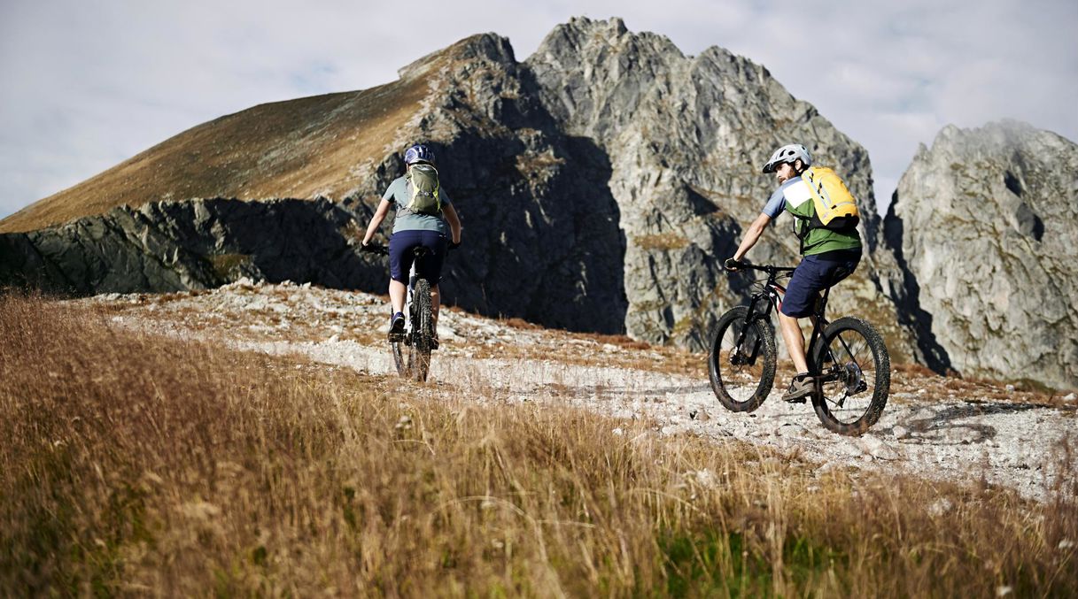 Due persone fanno un tour in mountainbike durante la loro vacanza a Scena