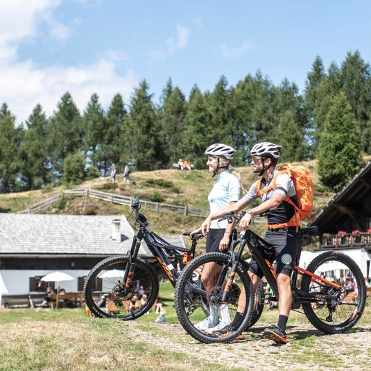 Two people on a mountainbike tour during their vacation in Scena/Schenna