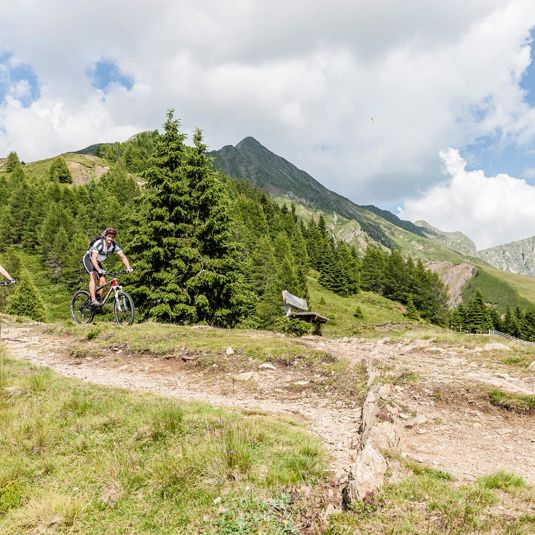 Due persone che fanno un giro in mountainbike durante la loro vacanza a Merano